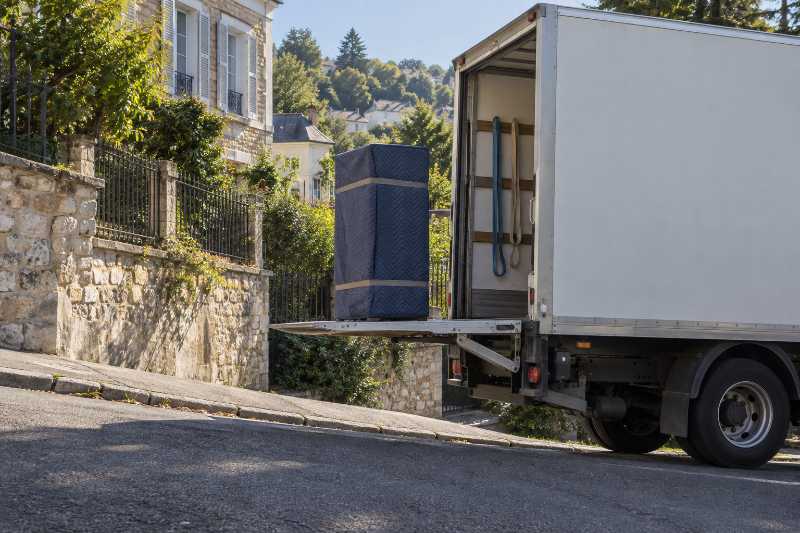 Armoire sous housse seule sur un hayon élévateur arrêté à mi-course