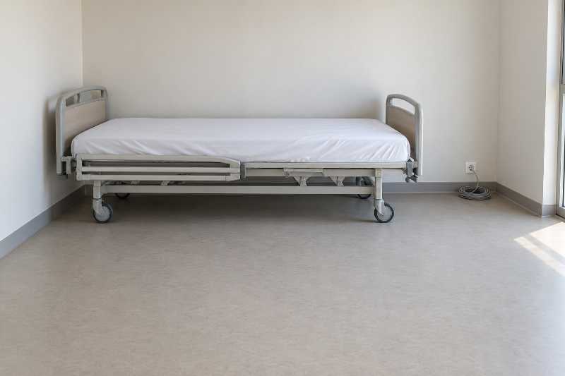 Lit médicalisé monté et installé au centre d'une chambre encore vide